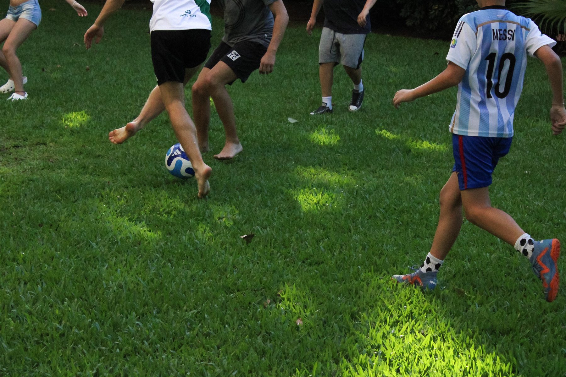 Kinder spielen Fußball auf einer Wiese
